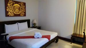 a bedroom with a bed with two towels on it at Swankaburi Boutique Hotel in Sawankhalok