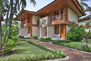 a house with a balcony and a yard at The Jayakarta Bali Beach Resort in Legian
