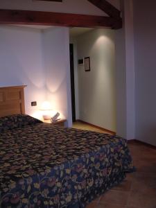 a hotel room with a bed and a lamp at La Locanda Del Melograno in Moncalvo