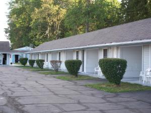 a white building with bushes in front of it at Great Lakes Motel in Fremont