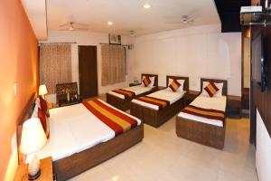 a room with two beds and a tv in it at Hotel Palace in Amritsar