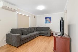 ein Wohnzimmer mit einem Sofa und einem Flachbild-TV in der Unterkunft Discovery Parks - Coogee Beach in Coogee
