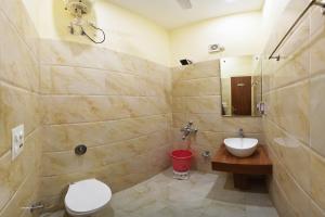 a bathroom with a sink and a toilet and a mirror at Hotel Palace in Amritsar