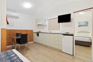 a room with a bed and a kitchen with a table at Discovery Parks - Coogee Beach in Coogee