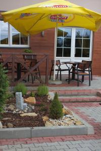 a patio with a table and a yellow umbrella at Hotel Pod Złotą Koroną in Opole