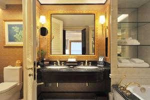 uma casa de banho com 2 lavatórios e um espelho grande em Grand Central Hotel Shanghai em Xangai