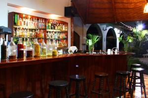 un bar con varias botellas de alcohol y taburetes en Hotel Villa de Valverde, en Ica