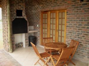 d'une terrasse avec une table, des chaises et un mur en briques. dans l'établissement Dronfield Reserve, à Kimberley