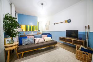 a living room with a couch and a tv at Feel Nazaré - Ocean View in Nazaré