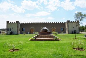 a building with a fountain in the middle of a yard at Die Kasteel in Hartswater