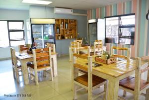 comedor con mesas y sillas de madera en Die Kasteel, en Hartswater