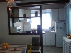 een keuken met witte kasten, een raam en een wastafel bij Villa Galinotis in Skaloma