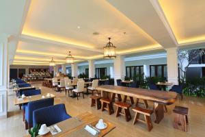 a restaurant with a long table and chairs at Grand Palace Hotel Sanur - Bali in Sanur