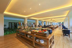 a buffet line in a restaurant with tables and chairs at Grand Palace Hotel Sanur - Bali in Sanur