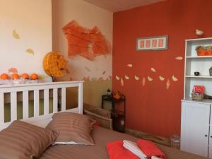 Cette chambre pour enfants dispose d'un lit et d'un mur orné de peinture orange. dans l'établissement B&B Marianne, à Bruxelles