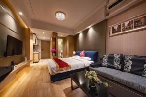 a hotel room with a bed and a couch at Heefun International Apartment - Zhujiang New Town FuLi Brand New World Plaza in Guangzhou