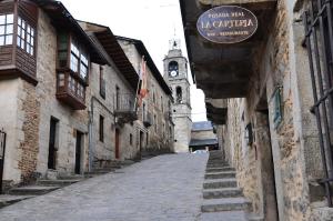 alejka z budynkiem z wieżą zegarową w obiekcie Posada Real La Carteria w mieście Puebla de Sanabria