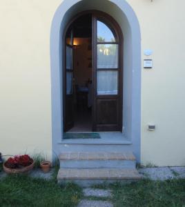 una puerta de entrada a una casa blanca con algunas plantas en Casa Roffi Esposito, en Pieve di Santa Luce