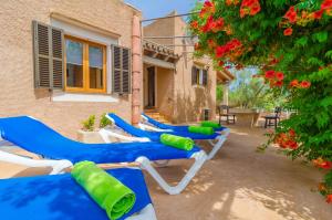 a row of blue and white lounge chairs next to a house at Cas General in Portopetro