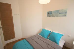 sypialnia z łóżkiem z niebieskimi poduszkami w obiekcie Apartment Palais de France w Nicei