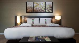 Cette chambre d'hôtel comprend un lit avec une table et un magazine. dans l'établissement Holiday Inn London - Whitechapel, an IHG Hotel, à Londres