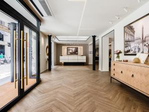 - un couloir avec une grande chambre dotée d'un bureau dans l'établissement Hotel Royal Saint Honore Paris Louvre, à Paris