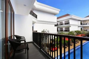 a balcony of a building with two chairs at Grand Palace Hotel Sanur - Bali in Sanur