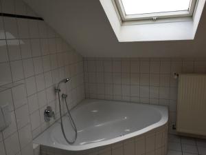 a bath tub in a bathroom with a skylight at Altes Gasthaus Stover in Löningen +34 photos