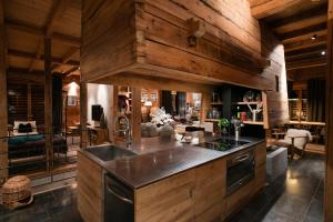 a kitchen with wooden walls and a stove top oven at La FERME des Lombardes in Saint-Jean-de-Sixt