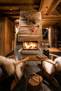 a living room with a fireplace and a table and chairs at La FERME des Lombardes in Saint-Jean-de-Sixt