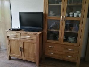 a wooden entertainment center with a television and a cabinet at Familienurlaub am See in Bodensdorf