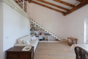 ein Wohnzimmer mit einer weißen Couch und einer Treppe in der Unterkunft La Casa Rossa in Lerici