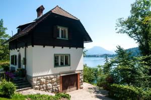 a small house next to a body of water at Sovica in Bled