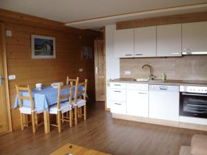 タウプリッツにあるWeideblickの白いキャビネット、テーブルと椅子付きのキッチンが備わります。