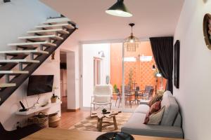 sala de estar con escalera, sofá y TV en Casa do Sul, en Évora