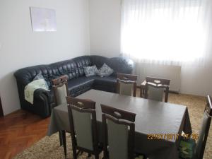 - un salon avec un canapé, une table et des chaises dans l'établissement Apartments Sandra, à Novigrad