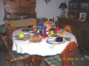 a table with a white table cloth with food on it at B&B Baita Evelina in San Giorio