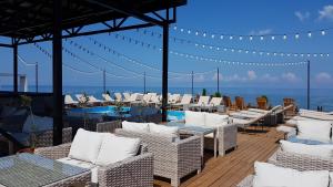 a patio with white wicker chairs and a view of the ocean at Boulevardside in Batumi
