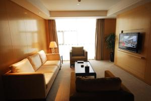 a living room with a couch and a tv at Wudang International Hotel in Shiyan