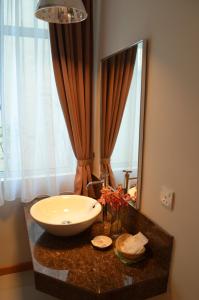 a bathroom with a sink and a large mirror at Hotel Asia in Kuah