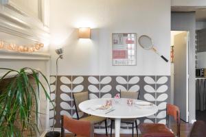 une salle à manger avec une table et des chaises blanches dans l'établissement Vintage by Cocoonr, à Rennes