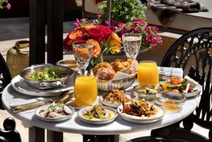 a table with plates of food and glasses of orange juice at Villa Brown Jerusalem, a member of Brown Hotels in Jerusalem
