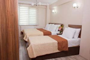 a hotel room with two beds and a window at Birlik Apart Hotel in Istanbul