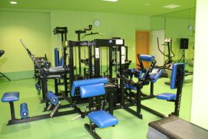 a gym with several tread machines in a green room at Golden Residence Hotel in Funchal