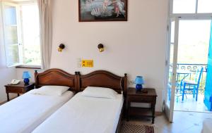 a bedroom with two beds and a balcony at Margarita Hotel in Kythira