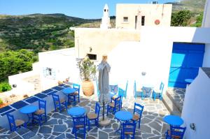 a patio with blue tables and chairs on a building at Margarita Hotel in Kythira
