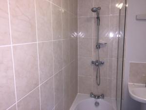 a bathroom with a shower with a toilet and a sink at Two Warehouse Apartments in Ulverston