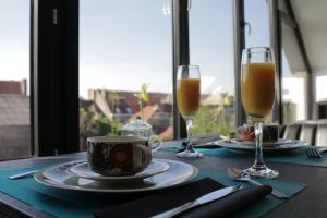 una mesa con dos copas de vino y una taza de café en B&B For 2-Wellness For 2 en Bruges