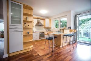a kitchen with a table and stools in it at Victus Apartamenty, Apartament Silver in Sopot
