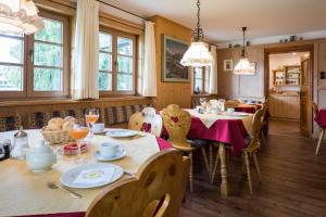 jadalnia ze stołami, krzesłami i oknami w obiekcie Gästehaus Walserheimat w mieście Riezlern